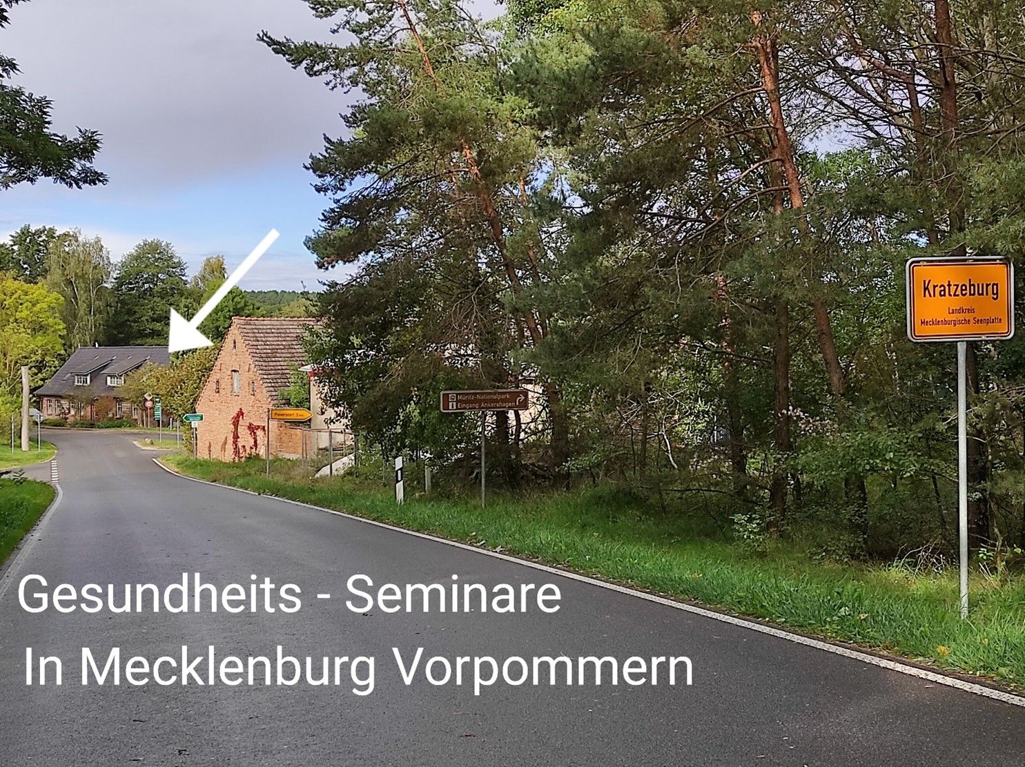Ortseingang von Kratzeburg mit Straßenschildern, einem Backsteinhaus und Text Gesundheits-Seminare in Mecklenburg-Vorpommern